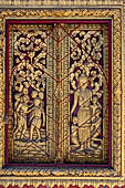 Luang Prabang, Laos - Wat Khili, the window shutters of the sim are decorated with gilded woodcarvings representing  probably the Prince Siddhartha. 